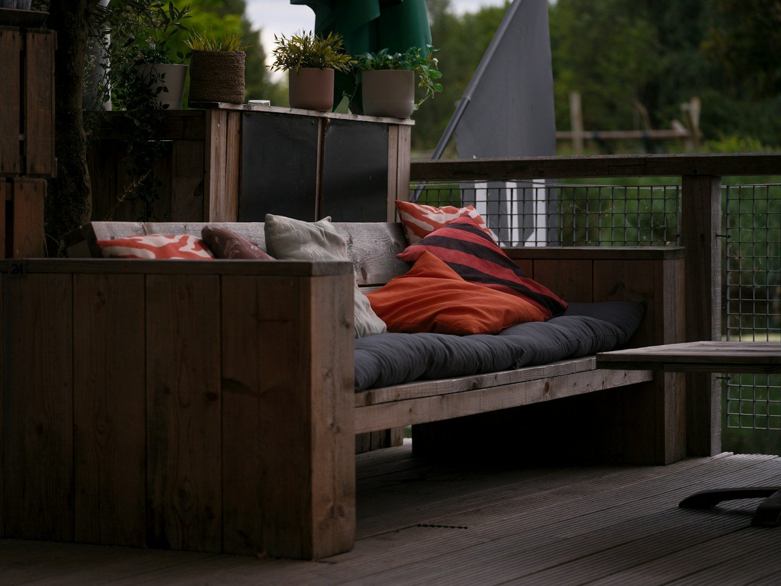Wooden outdoor sofa with colorful cushions on deck